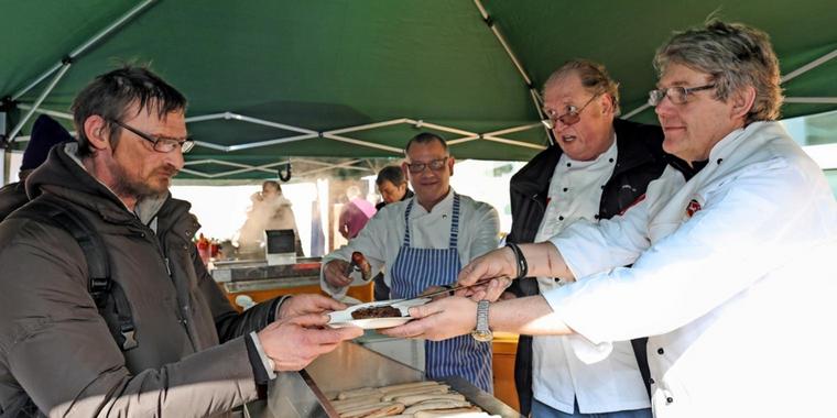 Cord Kelle (rechts) und Dick van Beuzekom (zweiter von rechts) kochen nicht nur, sondern verteilen auch die Mahlzeiten. Quelle: Tim Schaarschmidt